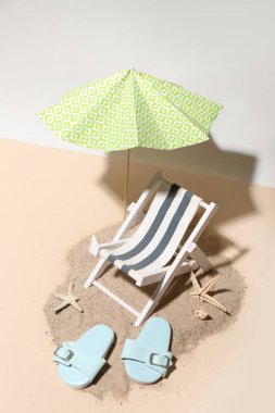 Renkli arka planda mini şemsiyeli, şezlonglu ve plaj aksesuarlı yaratıcı yaz kompozisyonu