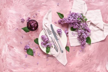 Pembe grunge arka planında leylak çiçekleri olan güzel bir masa.