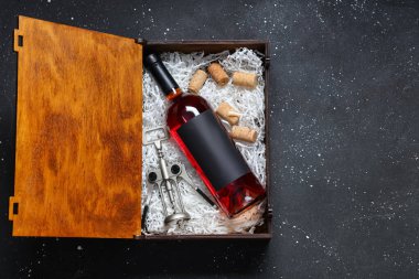 İçinde şarap şişesi, açacağı ve siyah grunge arka planda mantarı olan bir kutu.