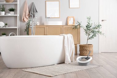 Kedi kumluğu, küvetin yanında kepçeyle oda.