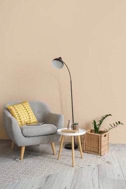 Oturma odasının içinde koltuk, masa ve lamba var.