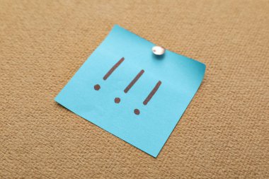 Üzerinde ünlem işaretleri olan yapışkan bir not.