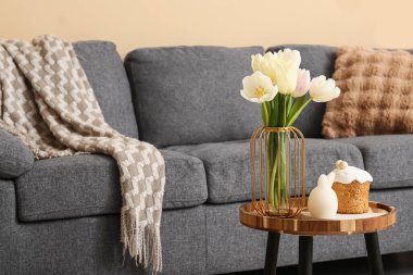 Salondaki masada laleli vazo ve paskalya pastası.