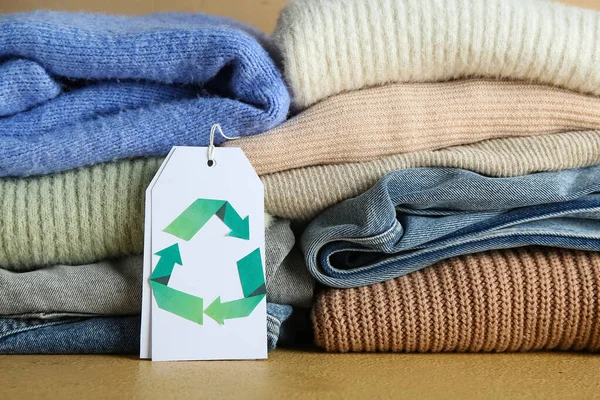 Masada geri dönüşüm logosu olan giysiler ve etiketler, yakın plan.