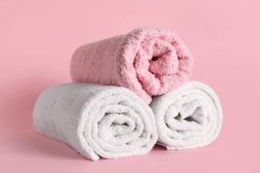 Pembe arka planda yumuşak havlular olan kompozisyon, yakın plan.
