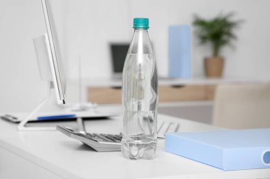 Ofisteki masada plastik su şişesi, yakın plan.