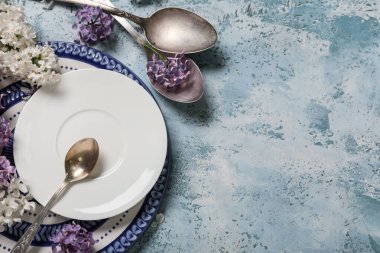 Mavi arka planda leylak çiçekleri olan güzel bir masa.