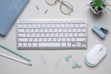 Beyaz arkaplanda klavye, fare ve kırtasiye ile kompozisyon