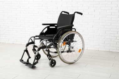 Beyaz tuğla duvarın yanında boş tekerlekli sandalye