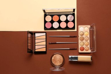 Güzel göz falı paletleri ve renkli arka planda farklı dekoratif kozmetikler.