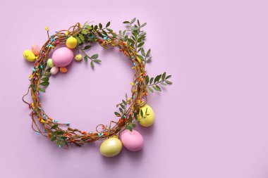 Paskalya çelengi, yeşil dallar ve leylak arkaplanda yumurtalar.