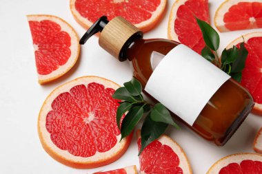 Beyaz arka planda bir şişe greyfurt serumu.