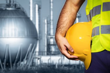 El veya kol mühendisi tutun petrol rafineri sanayi önünde sarı plastik kask