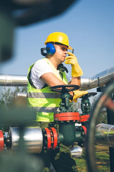 Ingenjör i arbetstagarens redskap inspekterar en ventil — Stockfoto