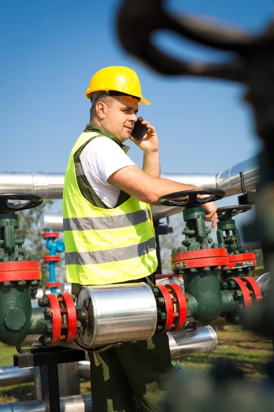 Trabalhador de petróleo usando telefone inteligente — Fotografia de Stock