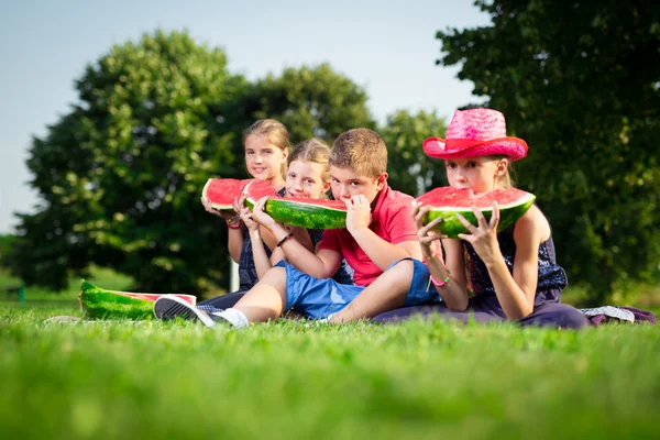 Милі діти їдять кавун у сонячний день — стокове фото