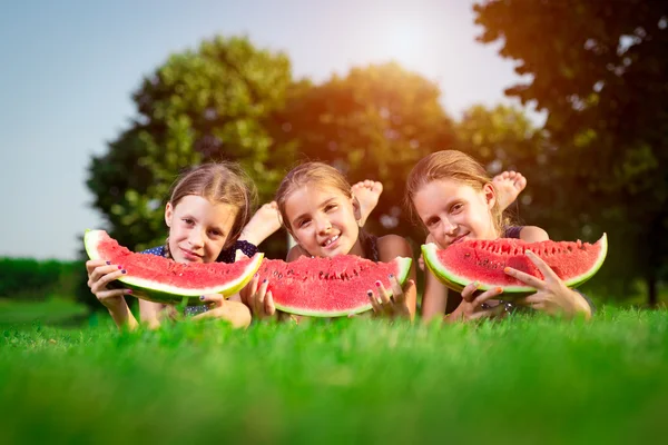 Kolme söpöä tyttöä syö vesimelonia — kuvapankkivalokuva