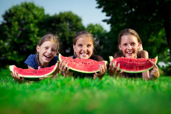 Drie leuke meisjes eten van watermeloen — Stockfoto