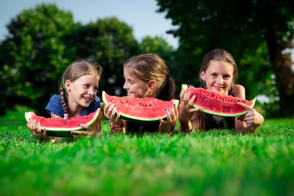 Drie leuke meisjes eten van watermeloen — Stockfoto