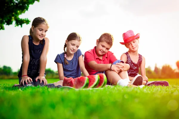 Schattige kinderen eten watermeloen op een zonnige dag — Stockfoto