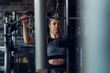 Genç fitness kadın spor salonunda egzersiz egzersiz makinesi ile yürütmek.