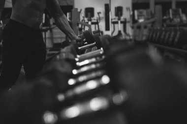 Güçlü vücut geliştirici halterleri kaldırıyor spor için hazırlanıyor.