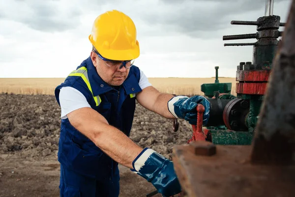 石油労働者は石油パイプラインでバルブを回している ガス産業 — ストック写真