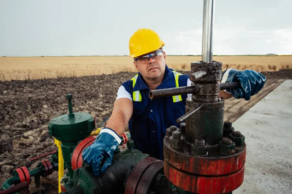 石油労働者は石油パイプラインでバルブを回している ガス産業 — ストック写真