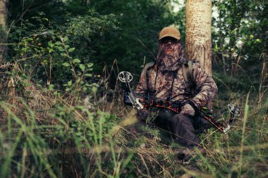 Okçuluk avcısı yayını geri çekmiş, atışa hazır.