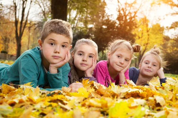 Child lying on the golden leaf — Stock Photo, Image