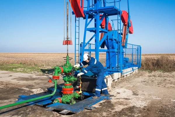 Ölarbeiter überprüfen Ölpumpe — Stockfoto