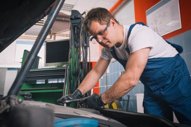 Otomobil tamir servisinde çalışan profesyonel araba tamircisi.