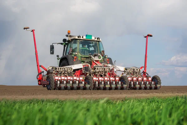 Tractor and seeder planting crops on a field — Stock Photo, Image