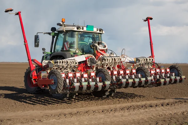 Trekker en zaaimachine aanplant gewassen op een veld — Stockfoto