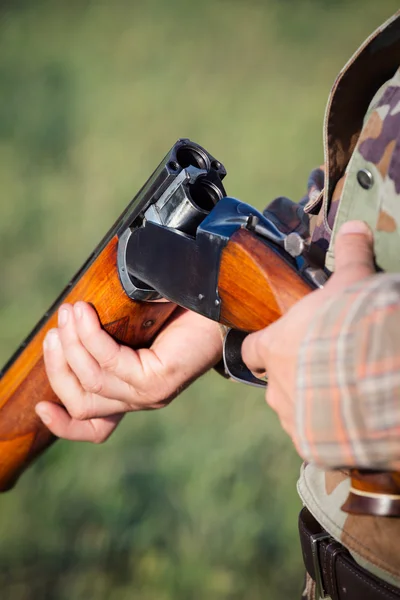 Jägare håller ett gevär — Stockfoto