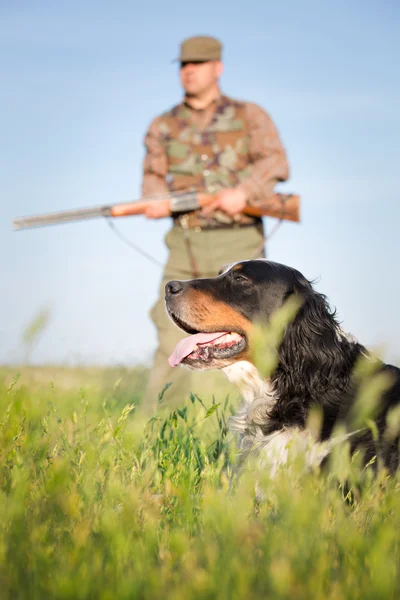 Jägare med hund siktar med sitt gevär — Stockfoto