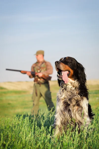 犬に向けて彼のライフルを持つハンター — ストック写真