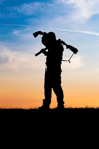 Chasseur avec fusil de chasse au coucher du soleil — Photo