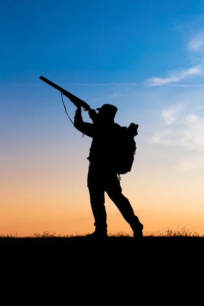 Hunter with shotgun in sunset — Stock Photo, Image