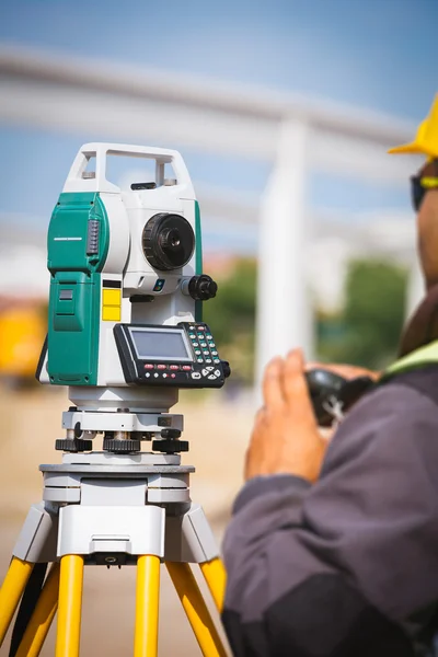 Surveyor inženýr pracovník tvorby, měření s teodolit zařízení na staveništi — Stock fotografie