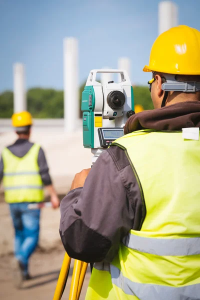 Surveyor ingenjör anställd att göra mätning med teodolit redskap utrustning på byggarbetsplatsen — Stockfoto