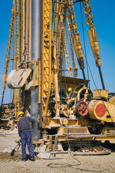 Construction site with workers and hydraulic drilling machines