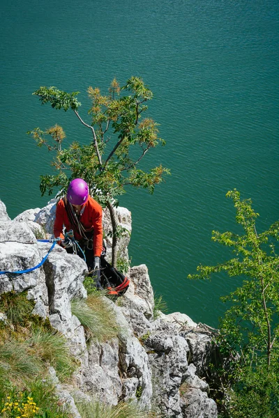 Woman adjusts climbing gear preparing climbing — Stock Photo, Image