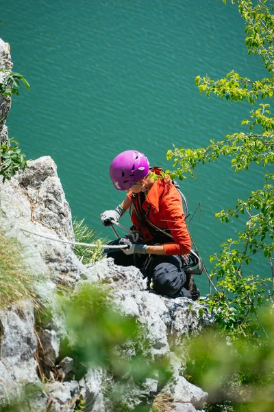 Woman adjusts climbing gear preparing climbing — Zdjęcie stockowe