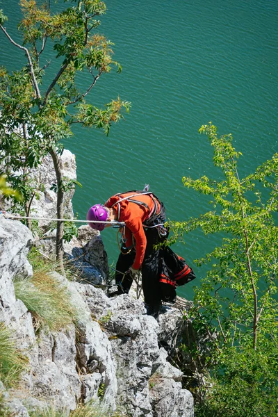 Woman adjusts climbing gear preparing climbing — Stockfoto