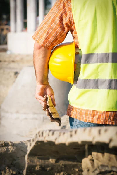 Obrero de la construcción sosteniendo hardhat amarillo — Foto de Stock