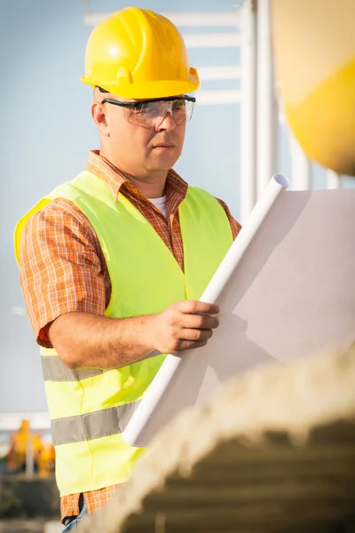 Gerente de construcción que controla el sitio de construcción con plan — Foto de Stock