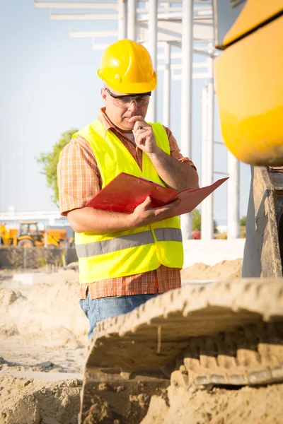 Gerente de construcción que controla el sitio de construcción con plan — Foto de Stock