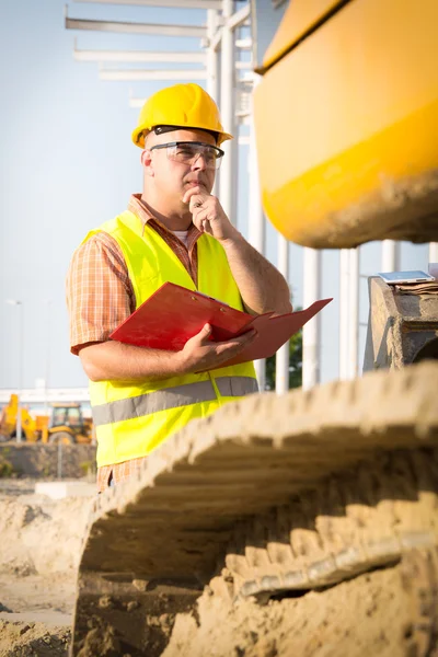 Gestionnaire de construction contrôlant le chantier avec plan — Photo