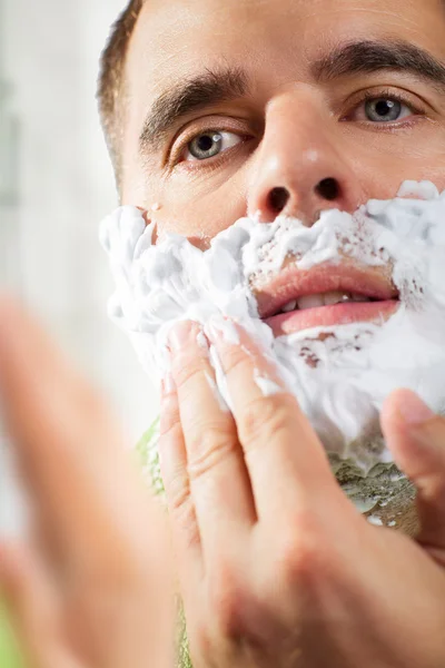 Bello giovane uomo si sta radendo il viso — Foto Stock